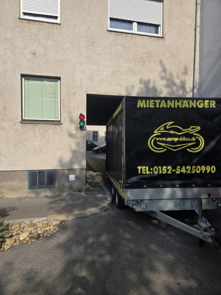 Umzugsanhänger in einer engen Hofeinfahrt in Wien mit wenigen Zentimetern Spiel