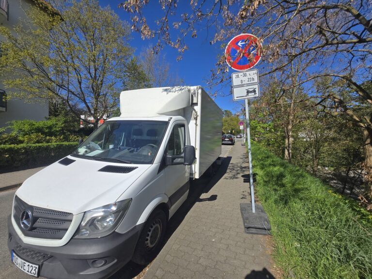 Aufgestelltes Halteverbotsschild mit Datumsangabe vor dem Umzugsfahrzeug