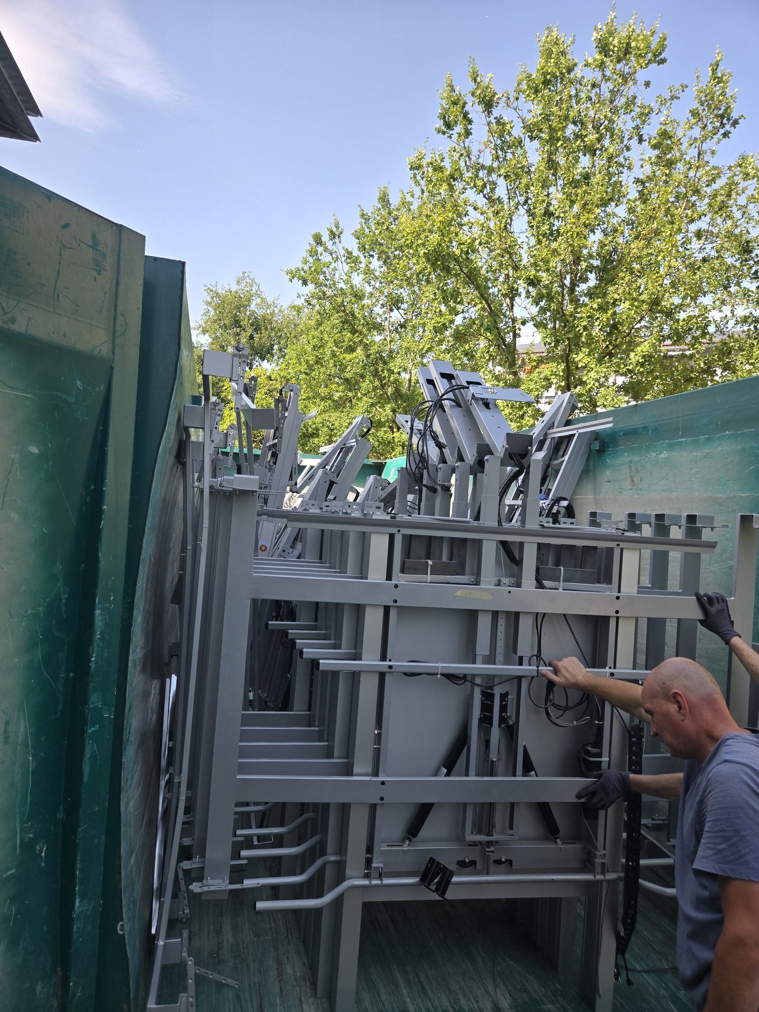 Demontage und Entsorgung aus einer Hand: sortenrein gestapelte Aluminiumgestelle werden in den Container verladen